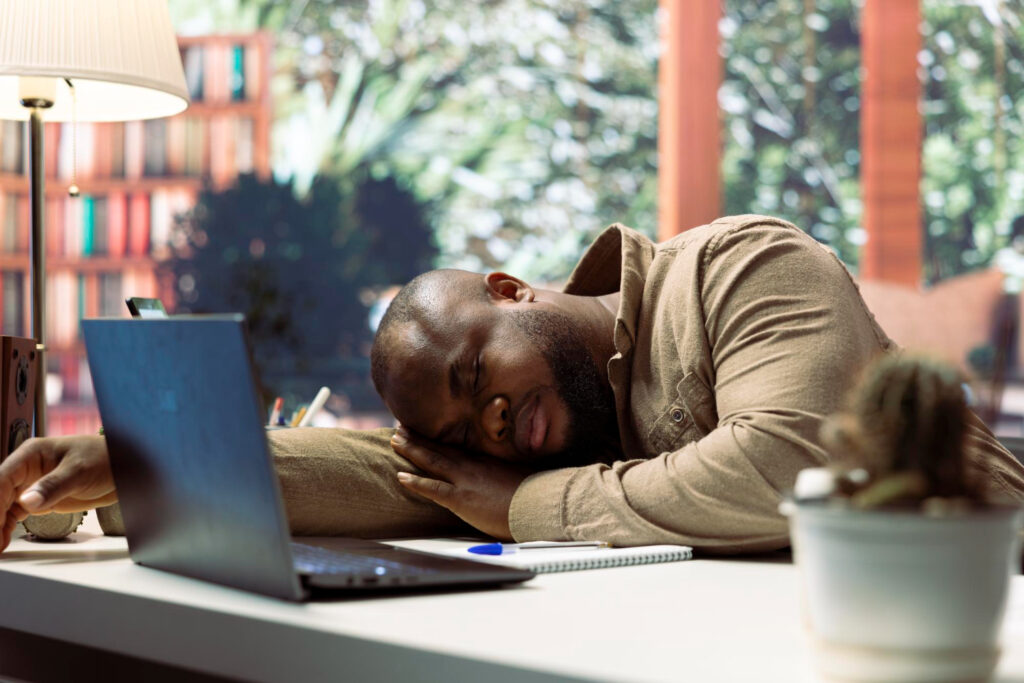 man resting head on table due to fatigue