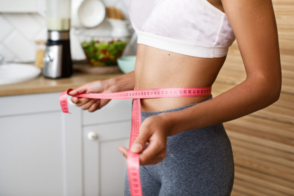 woman measuring waist with tape